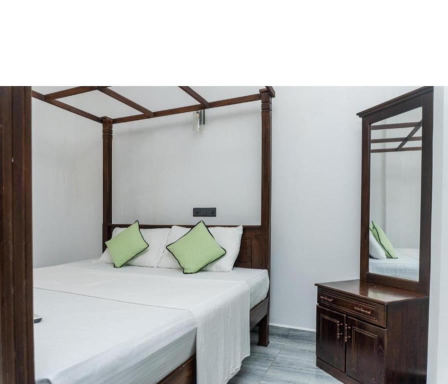 una camera da letto con un letto con specchio e una cassettiera di Blue Heaven Villa ad Ahangama