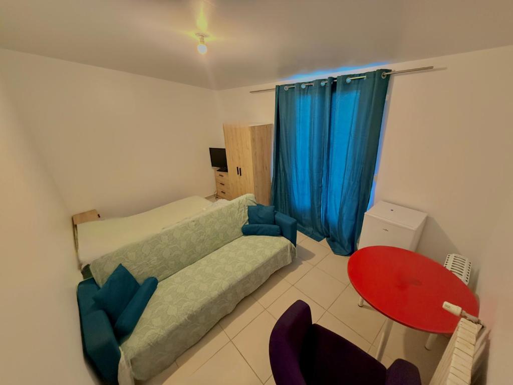 a bedroom with a bed and a red table at Maison Bon Séjour in Livry-Gargan