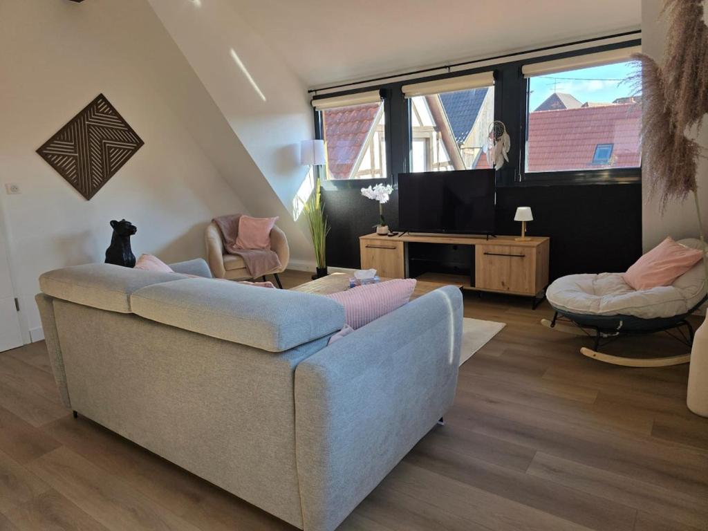 un salon avec un canapé et une chaise dans l'établissement La Valentine - Appartement proche marché de Noël - Wifi, à La Celle-sous-Gouzon