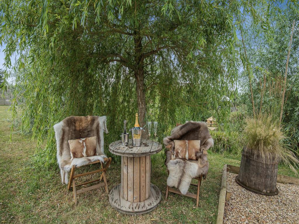 dos sillas y una mesa frente a un árbol en Bonnie's Shepherd Hut - Uk50228, en Nottingham