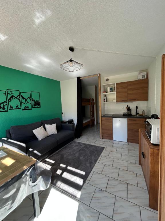 a living room with a couch and a kitchen at Appartement pour 4 personnes - Piau Engaly in Aragnouet