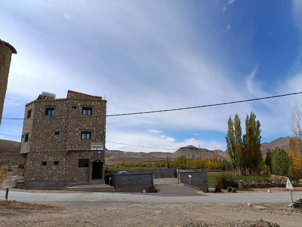 ein altes Steingebäude inmitten eines Feldes in der Unterkunft Auberge Restaurant Camping Taghzout in Agoudal