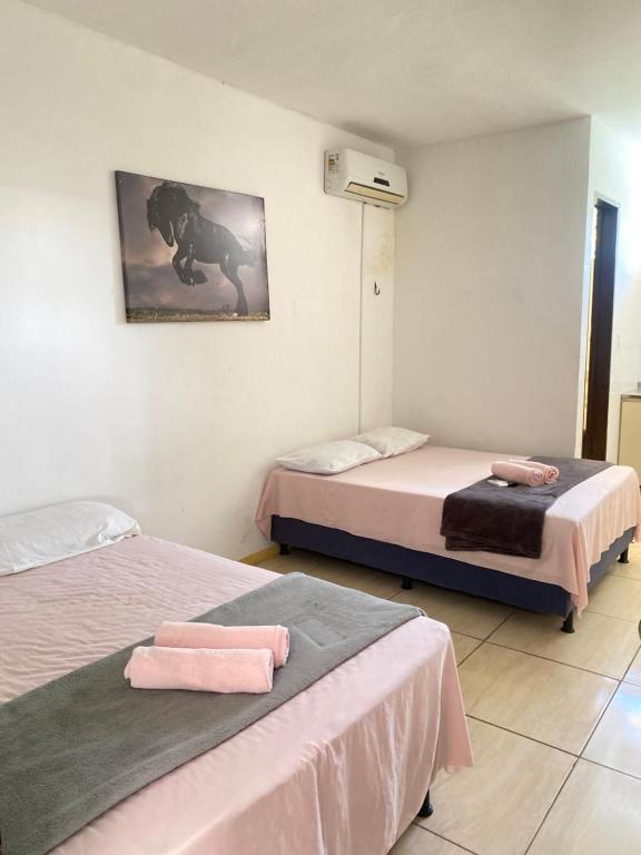 two beds in a room with pink sheets at Pousada Atlântico tambaú praia in João Pessoa