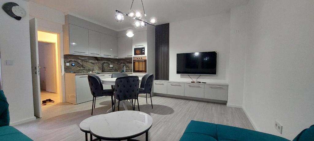 sala de estar con cocina con mesa y sillas en Apartman Vaske 2, en Brčko