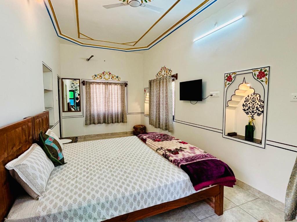 a bedroom with a bed and a tv at Hotel tulsi palace in Pushkar