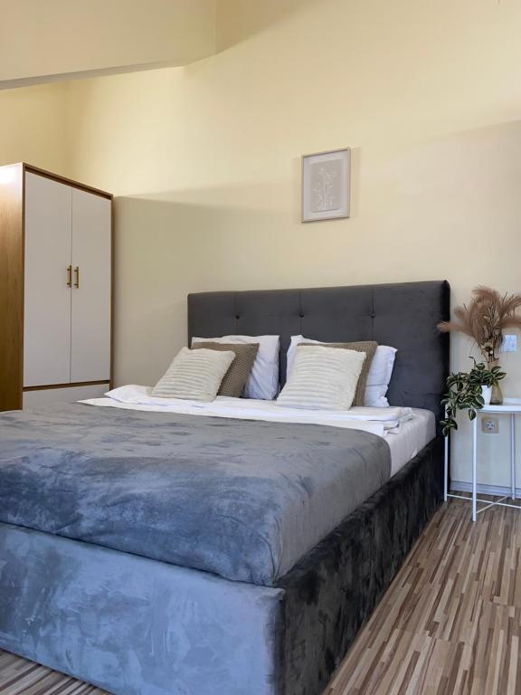 a bedroom with a large bed with white pillows at Garden Residence in Constanţa