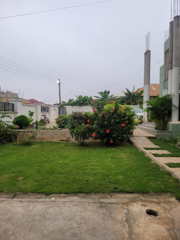 een tuin met bloemen in het gras bij The DomeApp Apartment in Kumasi