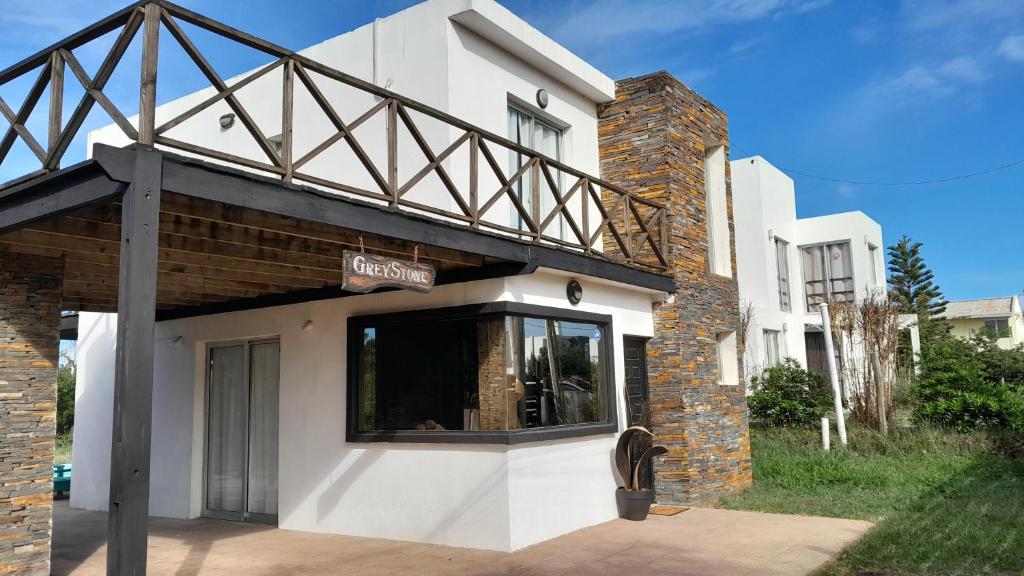 un bâtiment blanc avec une enseigne au sommet dans l'établissement GreyStone, à Balneario Buenos Aires