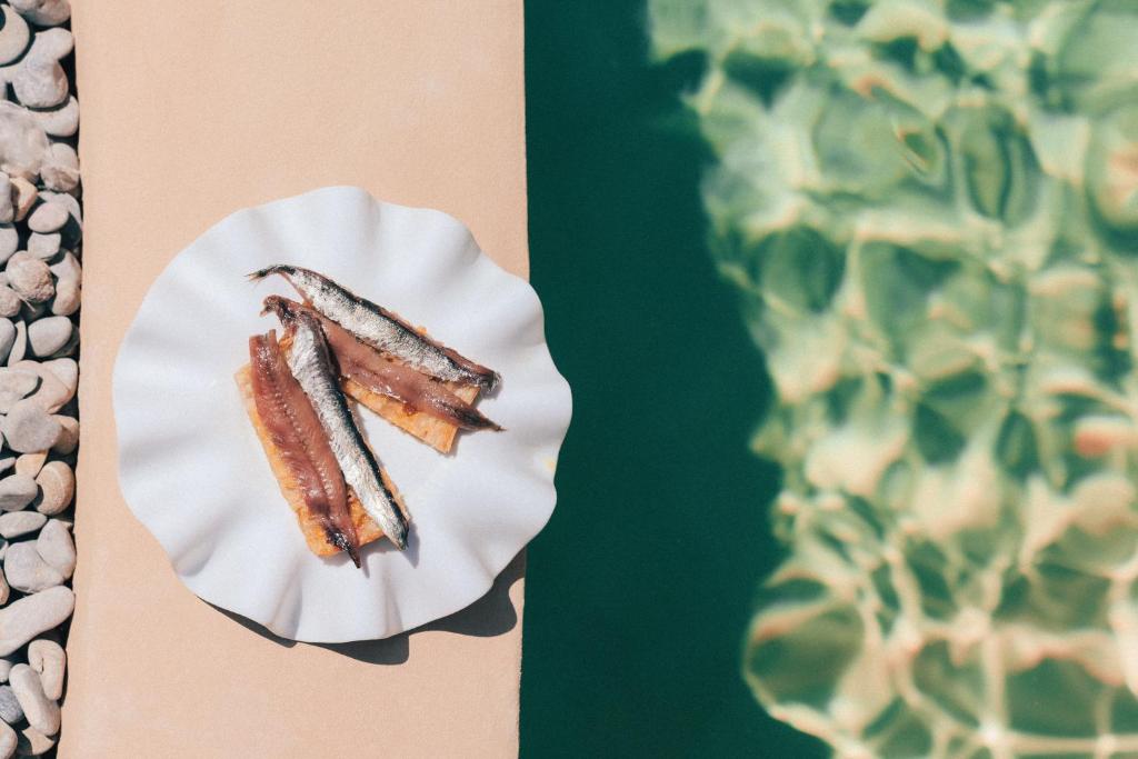 two pieces of food on a plate next to a cactus at Hotel Molí de l'Escala in L'Escala