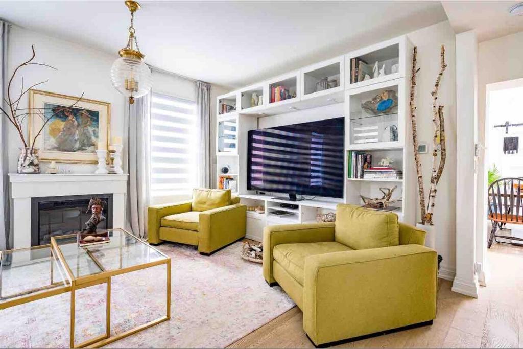 - un salon avec un canapé jaune et une télévision dans l'établissement Driftwood on 6th Heritage Downtown Collingwood, à Collingwood