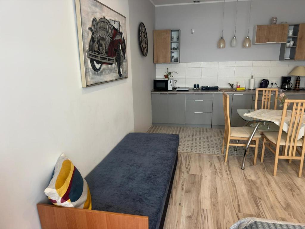 a living room with a table and a kitchen at Cichy Zaułek 9A in Brodnica