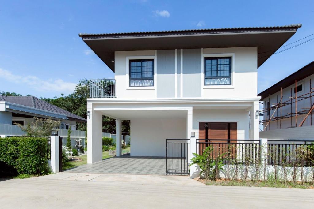 a white house with a black roof at Sleep Shot Pool Villa in Ban Fang Min