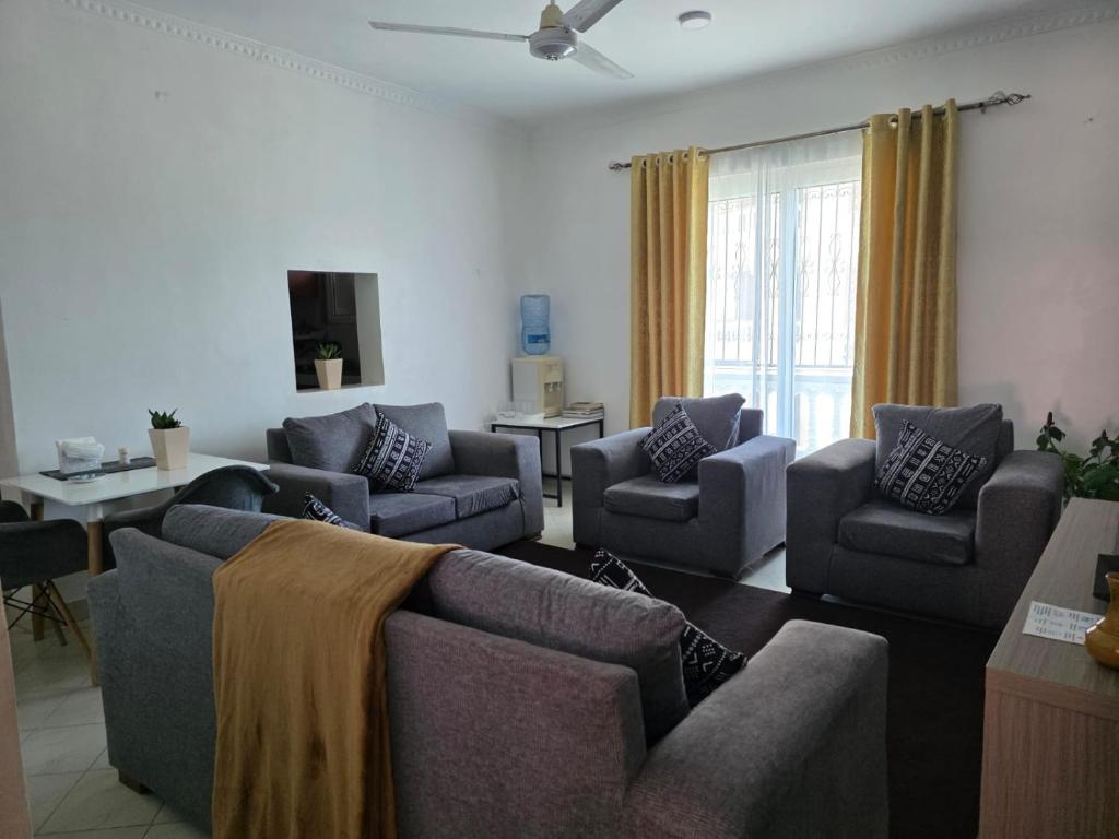 a living room with couches and chairs and a tv at SaltyNest in Gatunga