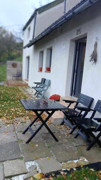 a picnic table and two chairs in front of a building at Chalupa ve Svinné in Svinná