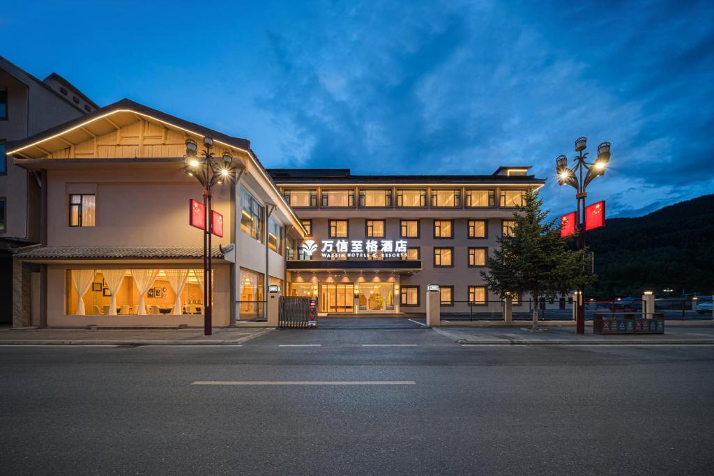 een groot gebouw met lichten ervoor bij Wanxin Zhige Hotel in Zhangla