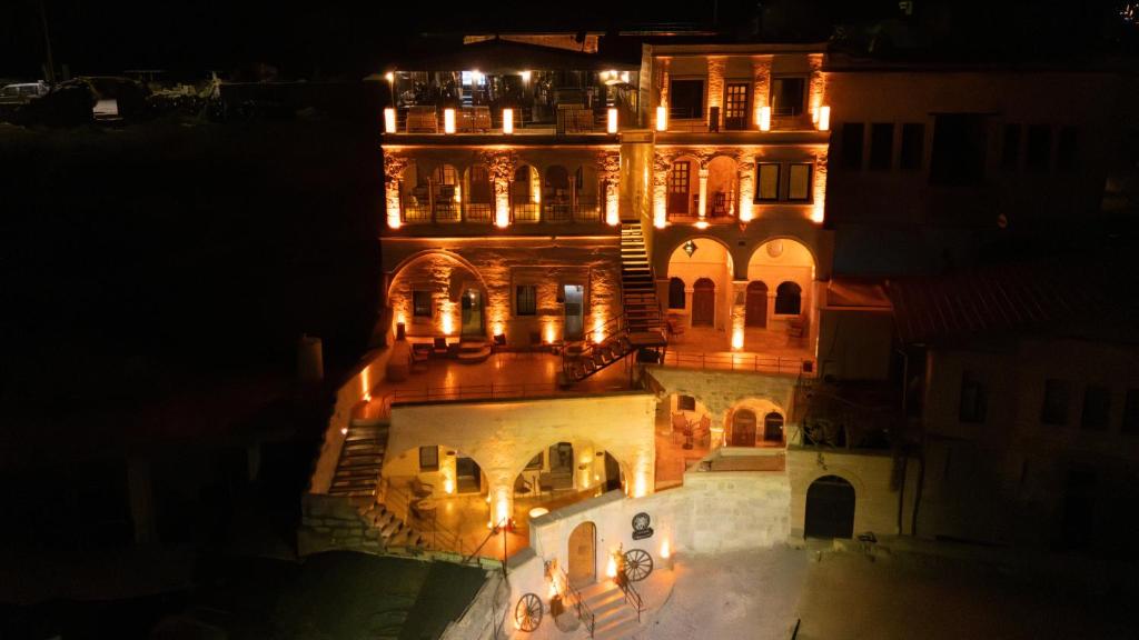 a large building with lights on it at night at Dionysos Cave Cappadocia Hotel in Urgup