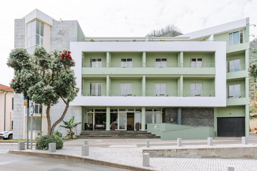 an apartment building with a green facade at Hotel Euro Moniz in Porto Moniz