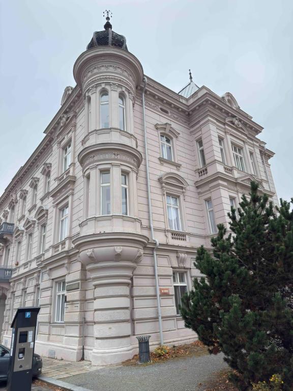 a large white building with a tree in front of it at Apartmán U Hradu in Strakonice