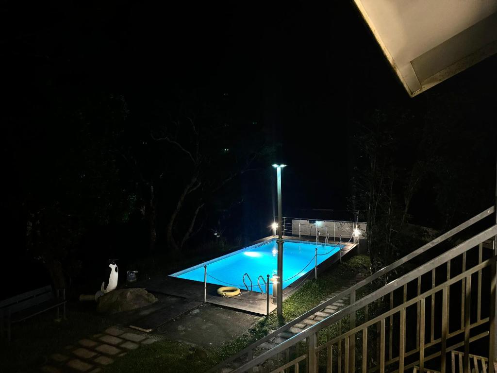 a swimming pool at night with a street light at Ninans Hide Out in Santhanpara