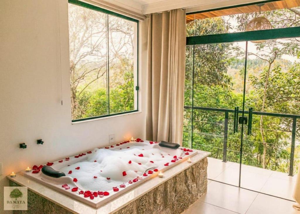 ein Bett in einem Zimmer mit einem großen Fenster in der Unterkunft DA MATA Chalés in Lindóia