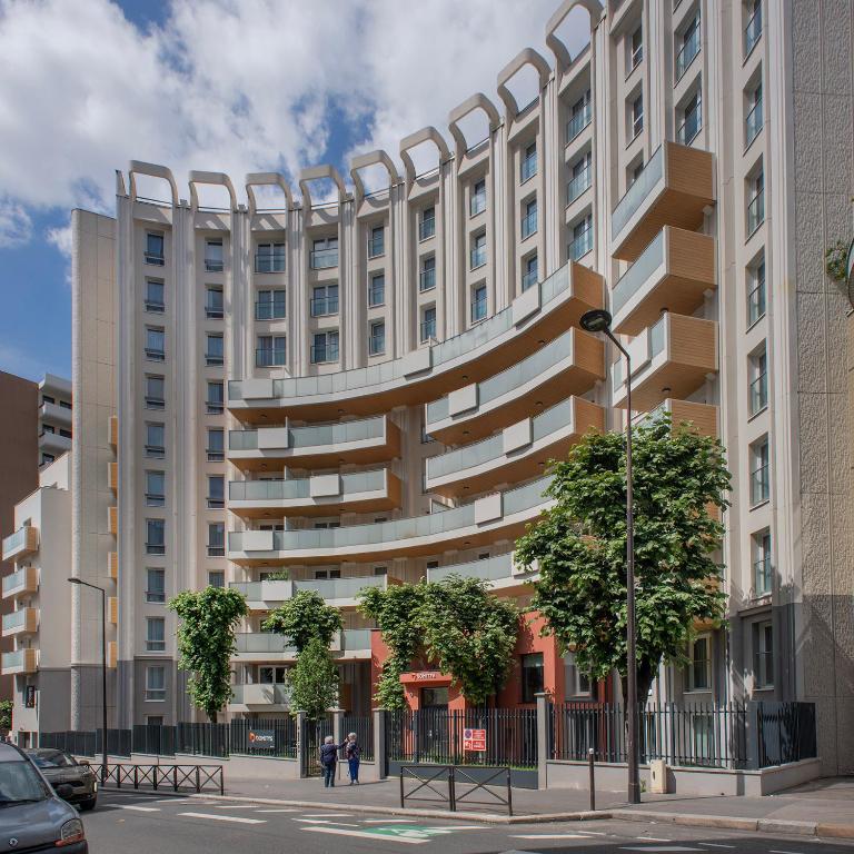a large white building with a curvy facade at Domitys L'Ellipse in Paris
