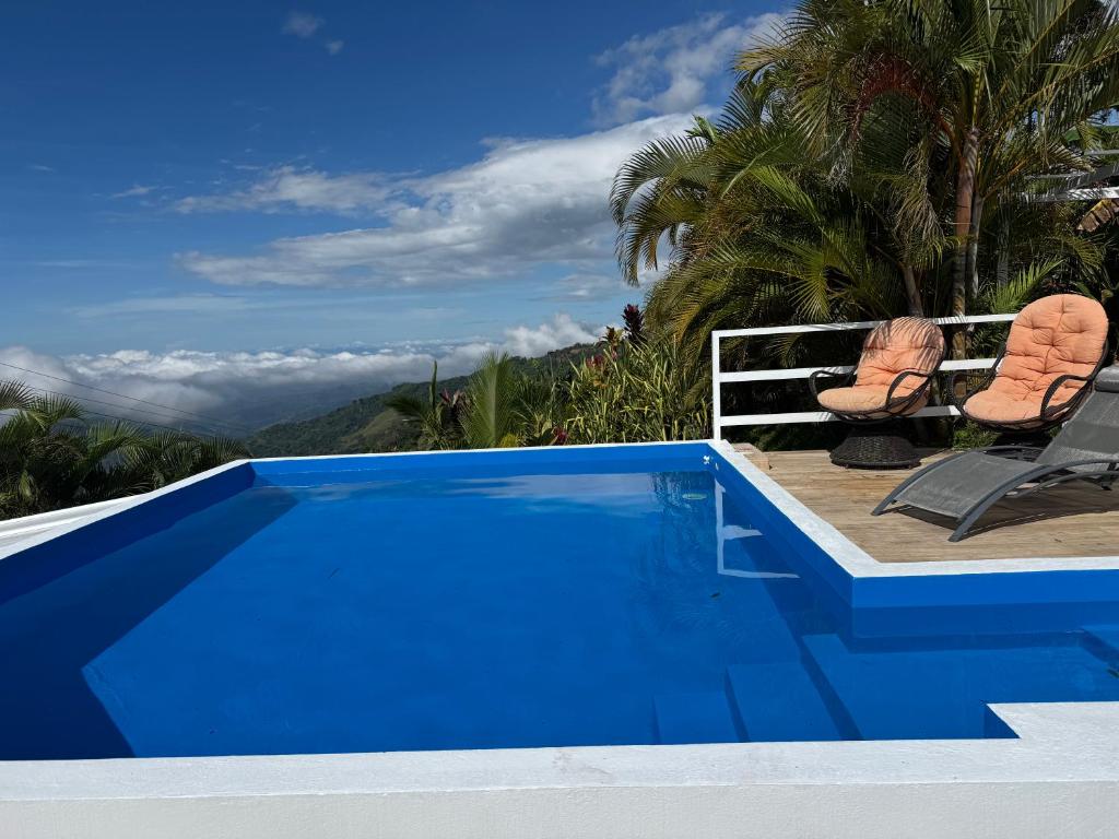 a blue swimming pool with two chairs next to it at Palco Pacífico Villa with Private Rooftop Pool in Alto del Monte
