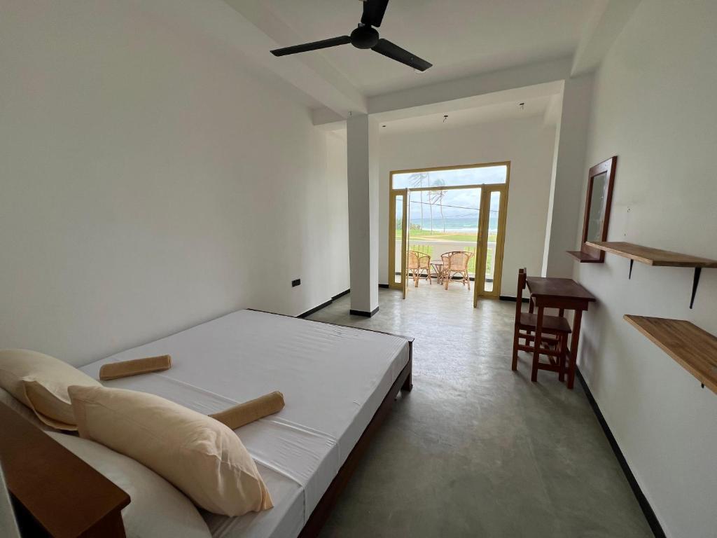 um quarto com uma cama, uma mesa e cadeiras em The Sunset Weligama em Weligama