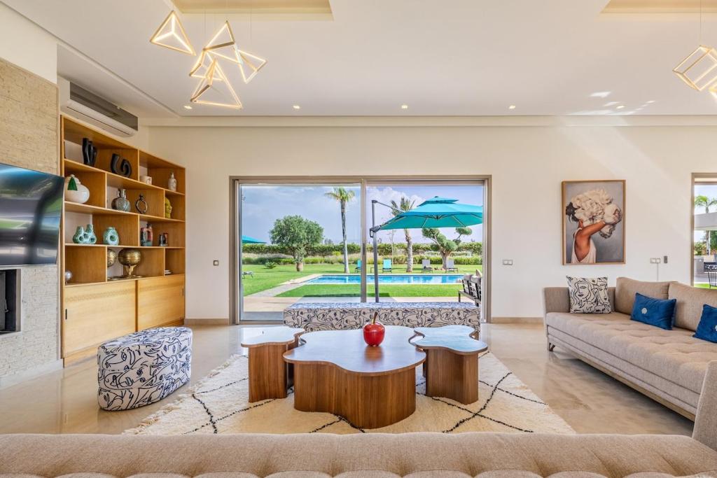 a living room with a couch and a table at Sublime villa, piscine chauffée, petit déjeuner inclus in Sehib Foukani