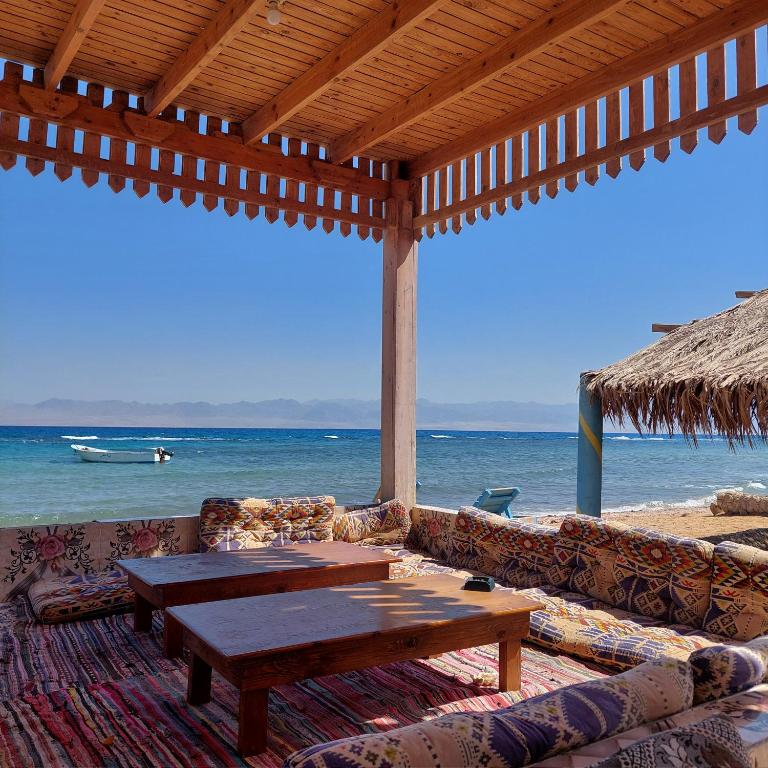 a living room with a table and couch on the beach at Shakazola Camp in Nuweiba