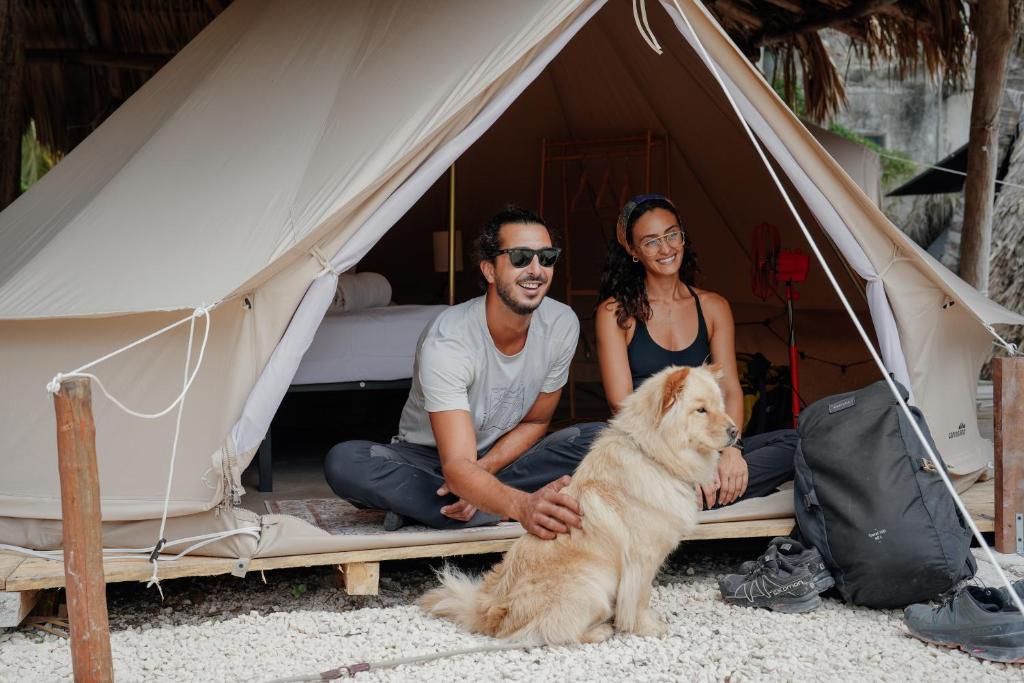 ホルボックス島にあるMapache Hostelの犬のテントに座る男女