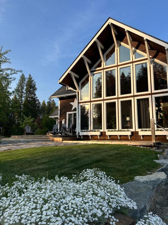 una casa con una ventana grande y algunas flores blancas en Lay Back Lodge, en Kimberley