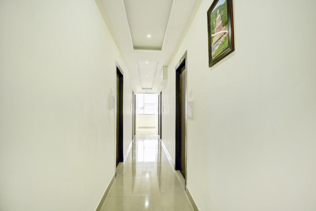 een hal met witte muren en een foto aan de muur bij Super Hotel O CITY HEIGHTS in Dhanbad