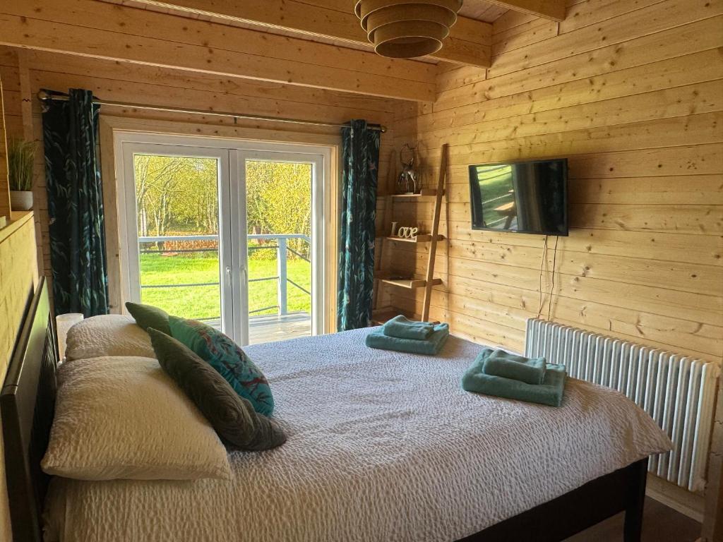 un dormitorio con una cama con dos almohadas. en Lake Lodge at Farthings Farm, en Clyst Saint Lawrence