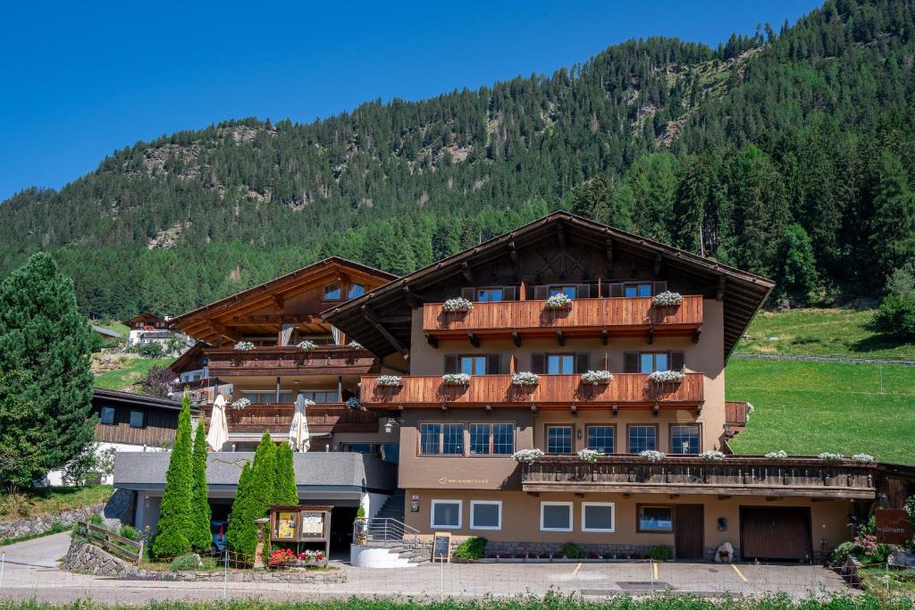 a building with a mountain in the background at Pension Widmann in Stulles