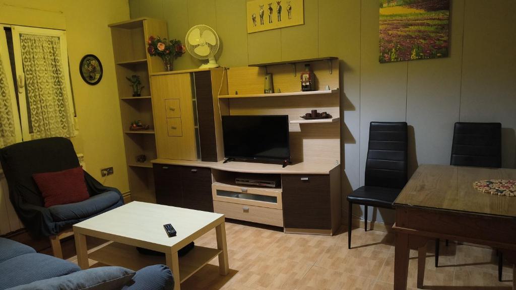 Una sala de estar con un televisor y una mesa. en CASA LOS BLOQUES, en Zamora