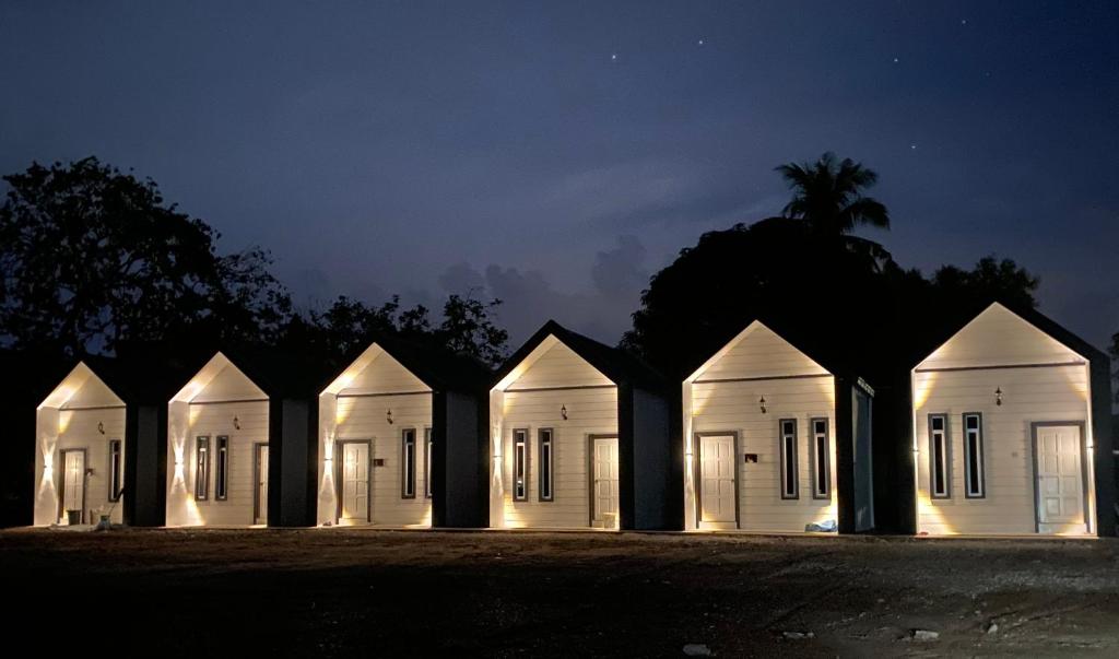 a row of white houses lit up at night at AZ Roomstay Pendang in Pendang