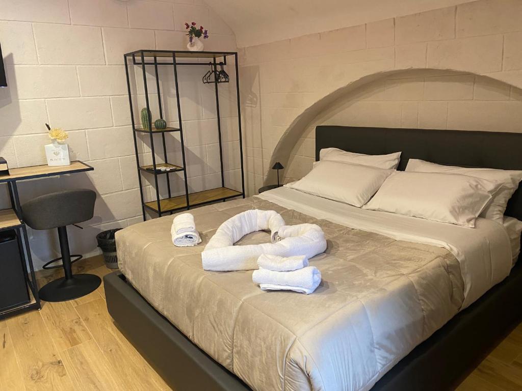 a bedroom with a bed with towels on it at Claustro Segreto - ALTAMURA in Altamura