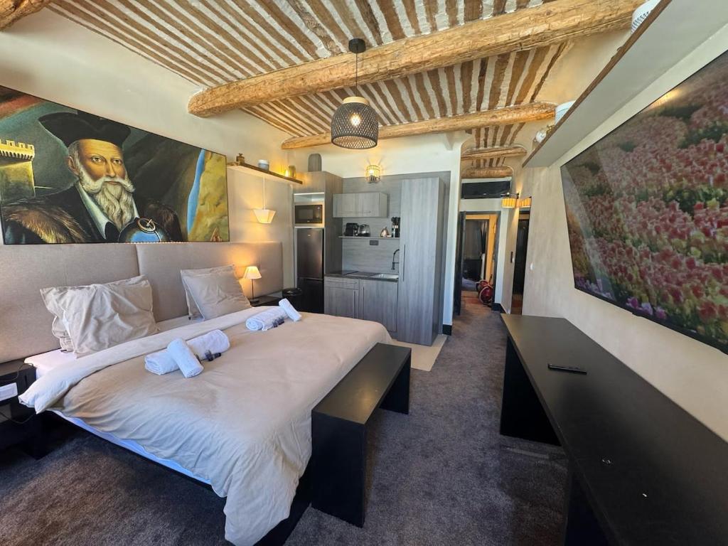 une chambre avec un grand lit avec un tableau au mur dans l'établissement Auberge Nostradamus, Appartement 4, à Salon-de-Provence