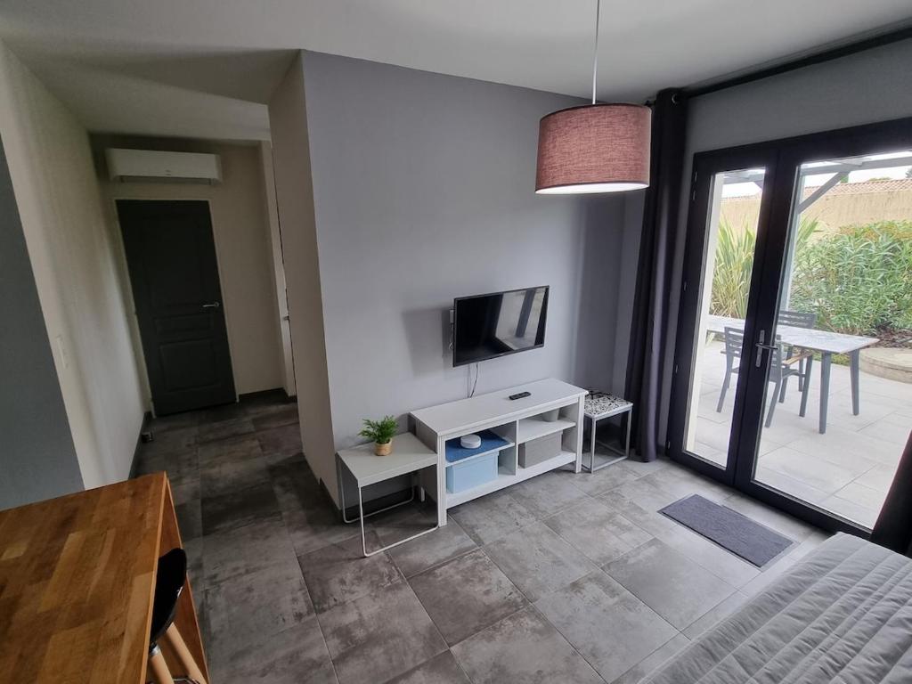 a living room with a television and a table at Le Cocon de Pinerato in Albi