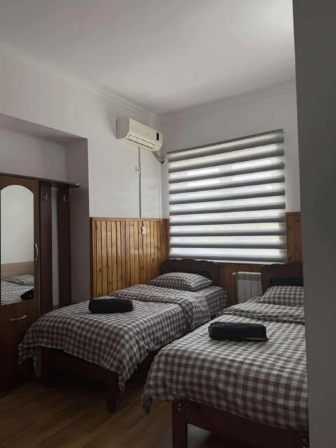 ein Schlafzimmer mit zwei Betten und einem Fenster mit Jalousien in der Unterkunft hotel olive in Rustawi