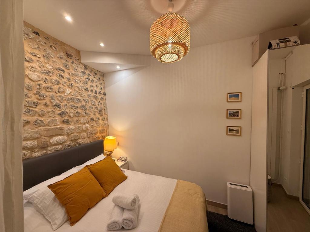 une chambre avec un lit et un mur en pierre dans l'établissement Maison Marie Charme & confort à Rouen centre, à Rouen