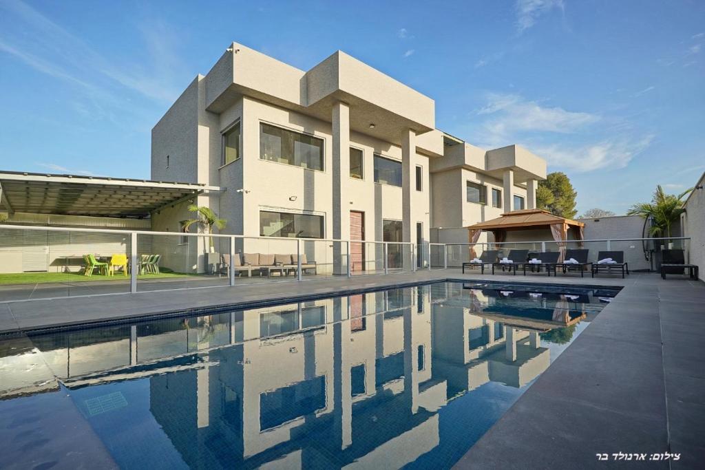 une maison avec une piscine devant dans l'établissement וילות היוקרה עידן הנוף ואחוזת אסתובן, à Ya‘ara