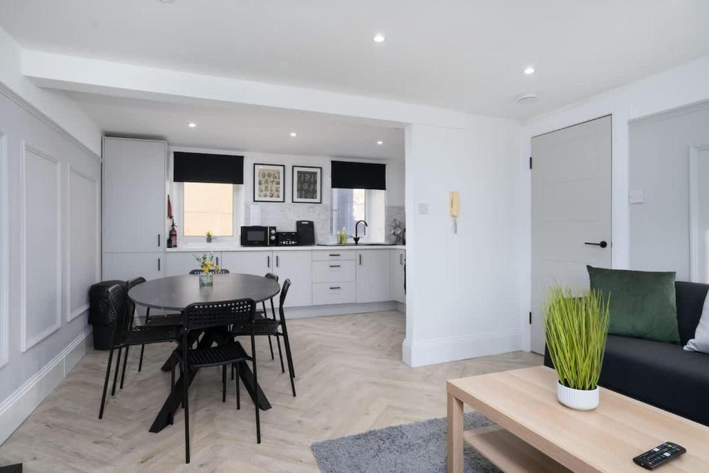 een keuken en woonkamer met een tafel en een bank bij Modern 5 BED-2 BATH Apartment in Galashiels