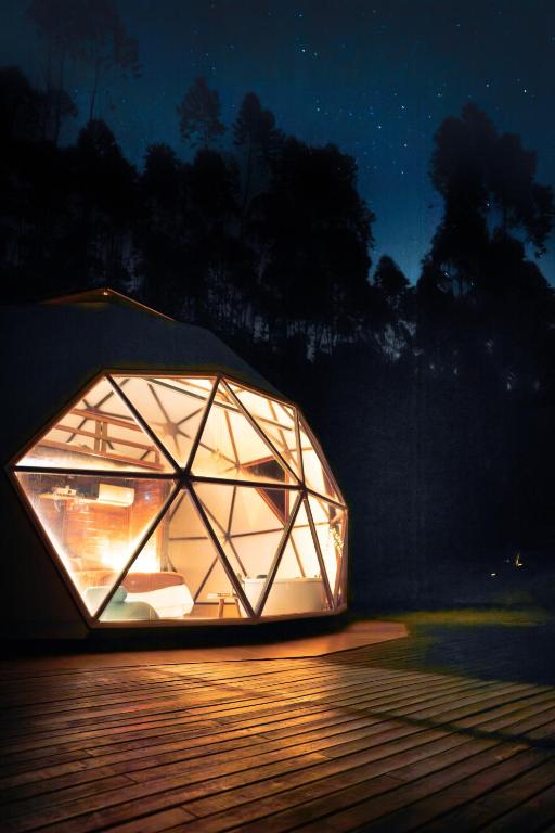 ein Kuppelzelt, das nachts auf einer Terrasse steht. in der Unterkunft Domo de Luxo com Jacuzzi e Vista Panorâmica in Salesópolis