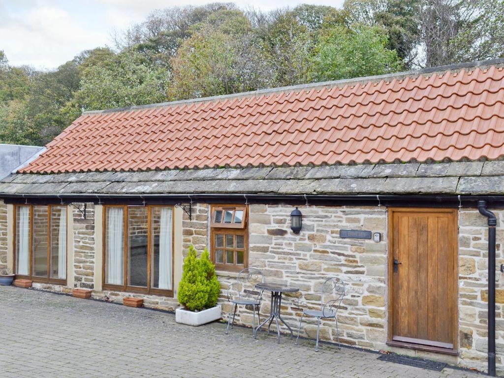 a stone house with a table in front of it at Yew Tree Bothy in Old Brampton