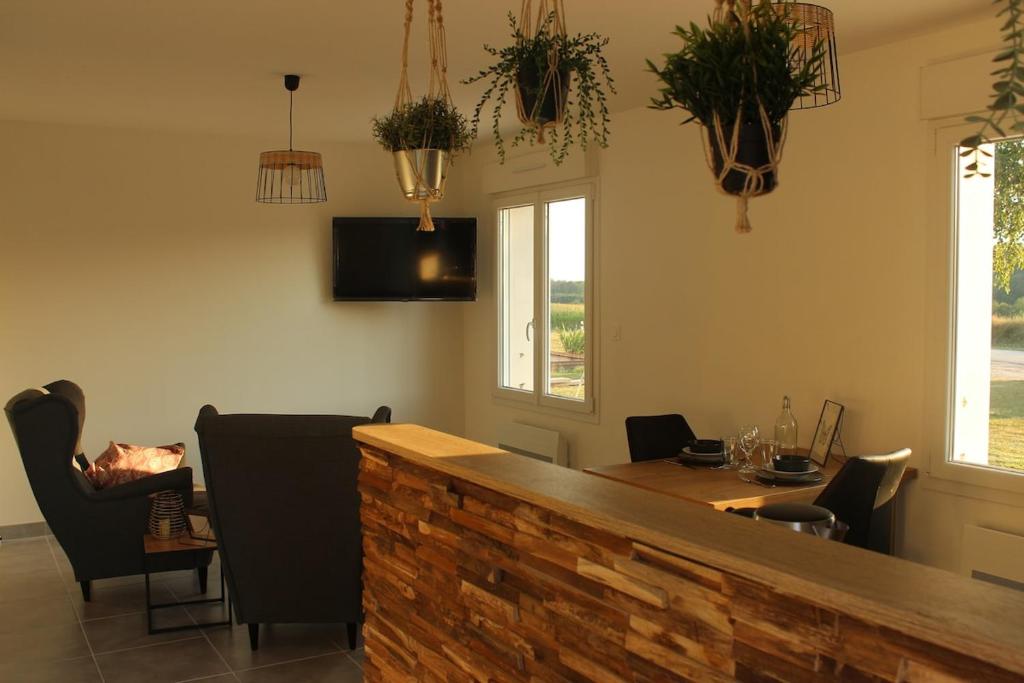 a dining room with a table and chairs and potted plants at Maison ROSAE Vinca 