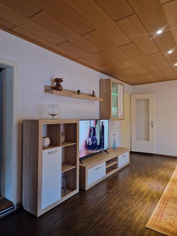 a living room with a flat screen tv and a wooden ceiling at Ferienwohnung-La Casa in Heidenheim