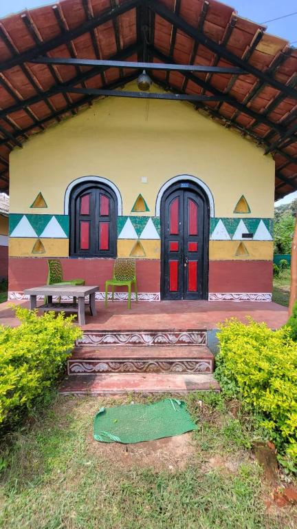 a building with red doors and a bench in front at La Bella Hotels and Resorts in Purulia