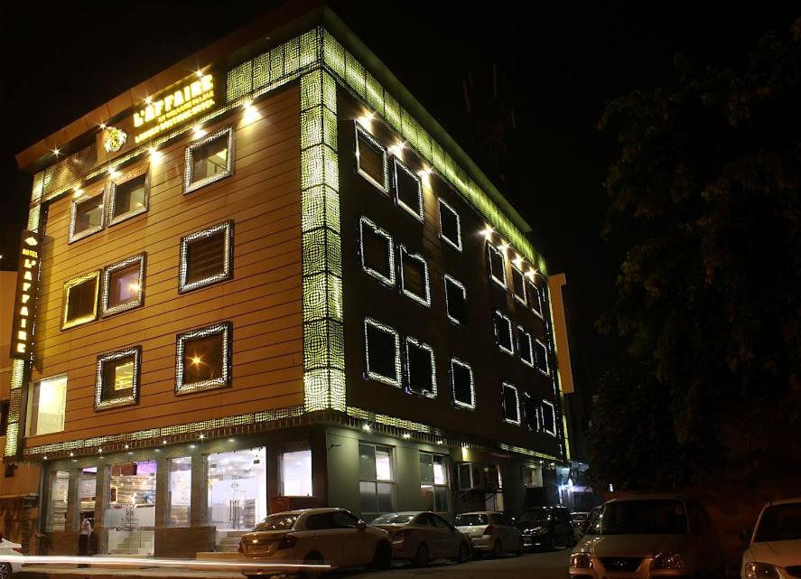 a building with cars parked in front of it at night at Hotel Laffaire by Welcome Palace in New Delhi