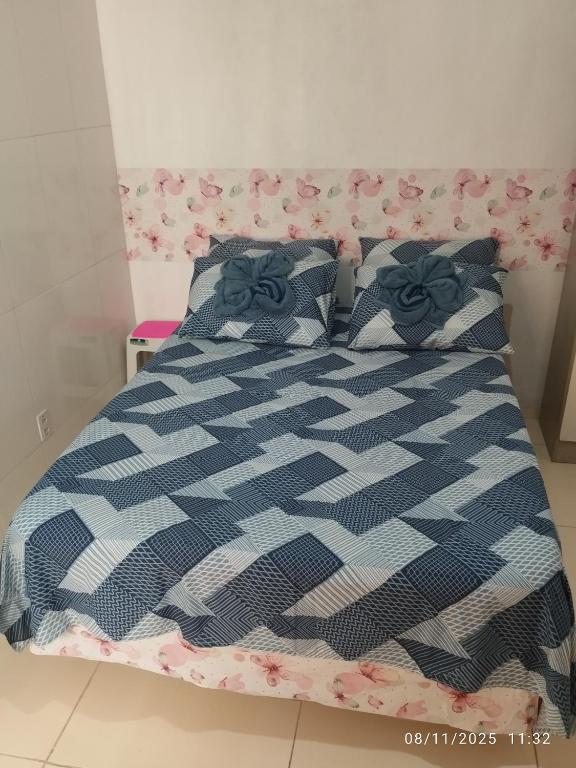 a bed with a blue and white comforter and pillows at Quarto próximo aeroporto, mangueirão, rodoviária, UFPA in Belém